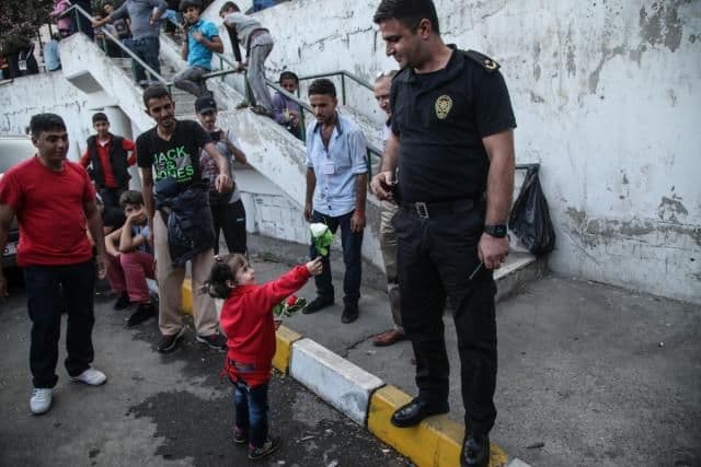 Fotografija koja je obišla svijet: Djevojčica nudi cvijet policajcu kako bi njena porodica prešla granicu Fotografija koja je obišla svijet: Djevojčica nudi cvijet policajcu kako bi njena porodica prešla granicu